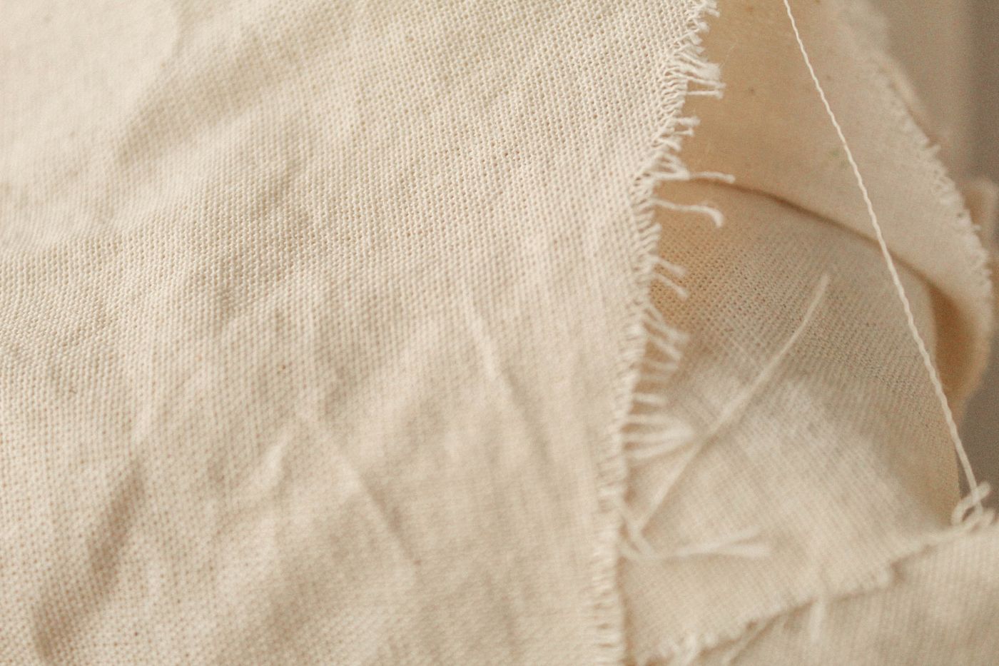 Close-up beige linen fabric texture for choosing shorts sewing pattern fabric